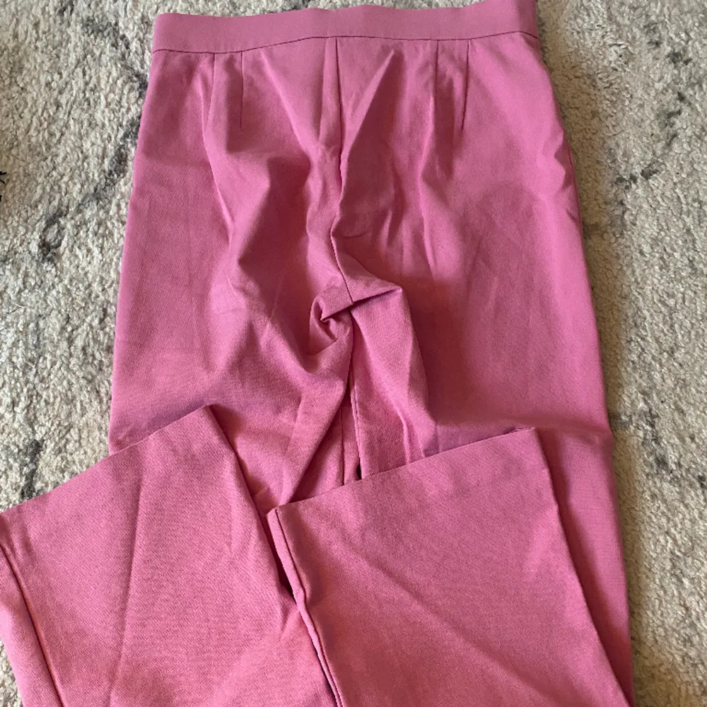 Ett par as balla rosa kostymbyxor från Zara, de är kortare i modellen som referens är jag 153cm! Storlek S, använda några få gånger så i mycket bra skick!🩷 Midjemått: 35cm Innerbenslängd: 62cm Ytterbenslängd: 88cm. Jeans & Byxor.