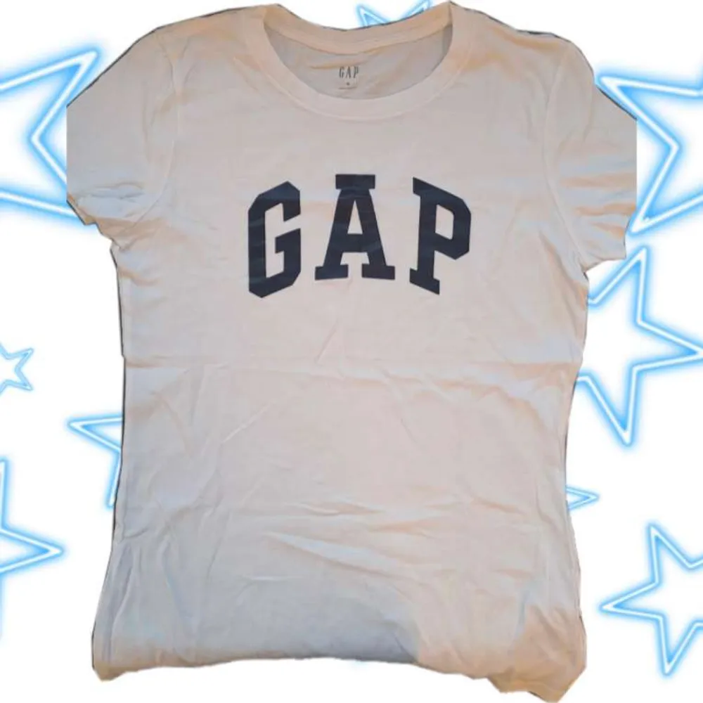 En vit GAP T-shirt med mörkblått tryck. Storlek M ☆Använd köp nu! Skriv vid frågor eller fler bilder ☆. T-shirts.