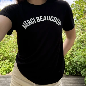 T-shirt med tryck - Svart lite tunnare t-shirt med vitt, franskt tryck från River Island. Storlek: (UK) 12. Material: 51% polyester + 49% viskos. Lite lätt nopprig som ej går bort med ”nopp-maskin” men inget som är jättesynligt då den är svart. :)