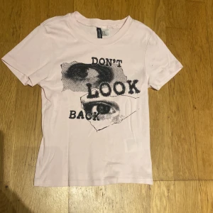 Rosa t-shirt med design  - En rosa tröja med en design i svart och den är i bra skick 