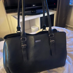 Svart väska från Don donna - Svart väska från dondonna! Perfekt till vardags!  tre fack i! Flera olika fickor och fack! den är väl använd så därav det låga priset🥰 finns tillhörande axelband!