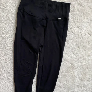 Svarta leggings från Stronger - Ett par svarta träningsbyxor från Stronger med ribbad linning. Nypriset var 700kr. Leggingsen är tillverkade i ett stretchigt material och är väldigt sköna! Kontakta mig för fler bilder eller vid intresse! Pris kan diskuteras❣️