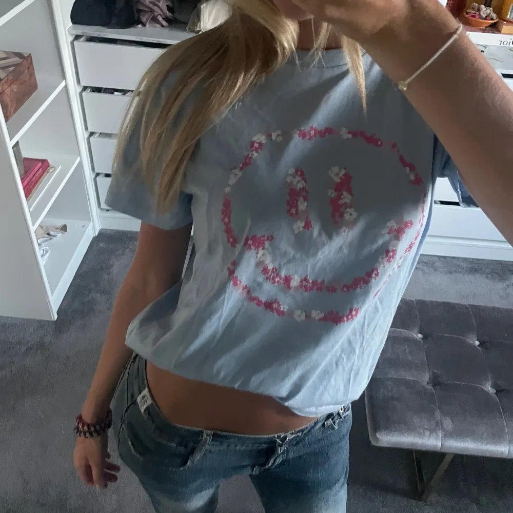 Blå tshirt med rosa smiley. T-shirts.