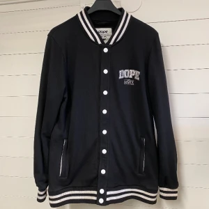 Dope Jacka - Sparsamt använd baseballjacka i fint skick. Perfekt vår och höstjacka. Fickor med dragkedja. Strl. M (herr). Frakt tillkommer. 