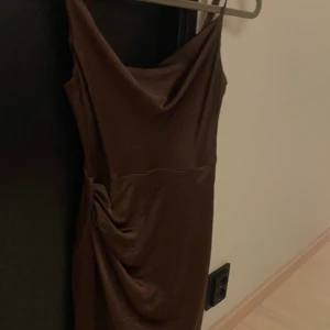 Brun glansig klänning  - Fin brun klänning i nyskick som glänser🫶🏼 Använd en gång på sommaren och har inga defekter alls. Nypris 400kr, mitt pris 200kr💗