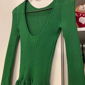Somrig grön tröja med öppen rygg. Det går dessutom att ha den bak och fram så att det bildar en u-ringning. Super stretchigt material. Tveka inte höra av er vid fler funderingar!☺️