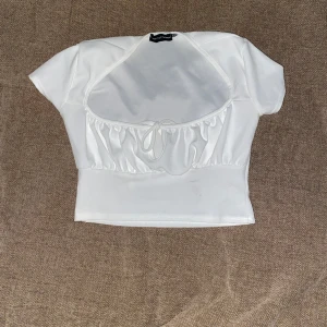 croptop med volanger - en croptop i volanger som är oanvänd men utan prislappar, det finns en liten dammfläck vid den nedre delen som uppstått i samband med flytt men tröjan kommer att fraktas nytvättad! i storlek 36 från prettylittlething