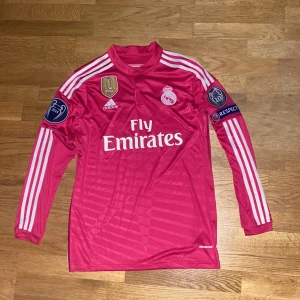 Real Madrid 2014-2015 borta tröja Ronaldo  - Real Madrids borta tröja från 2014-15 säsongen med Ronaldo #7 på ryggen 🇵🇹tröjan har också UCL och club world cup Badges. tröjan har aldrig använts (Pris kan diskuteras)
