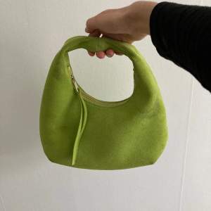 Knappt använd limegrön mockaväska, kommer inte till användning. Har en liten fläck på ena sidan som säkert går att ta bort  Köparen står för frakt