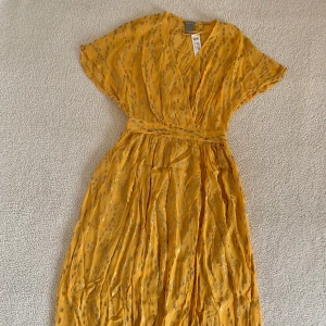 Lindex gul / guldig långklänning - Otroligt vacker gul sommarklänning från Lindex med guldigt skimmer. Ny med tags kvar, utan anmärkningar. Ordinariepris 699kr.