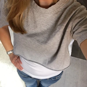 Kroppad trendig t-shirt  - En snygg trendig topp i grått som passar till en spetstopp eller ett linne! Har inte kommit till användning men är i fint skick💕