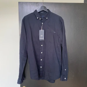 Navy skjorta, Lindbergh - Helt ny linneskjorta från Lindbergh, perfekt till sommaren. Storlek M, sitter som M. Nypris 700kr, finns i Sollentuna. 