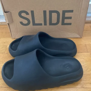 Yeezy Slides - Säljer dessa svarta Yeezy slides pågrund av att de blivit för små för mig. Dem är i bra skick bara lite smutsiga. Pris kan diskuteras vid snabb affär.
