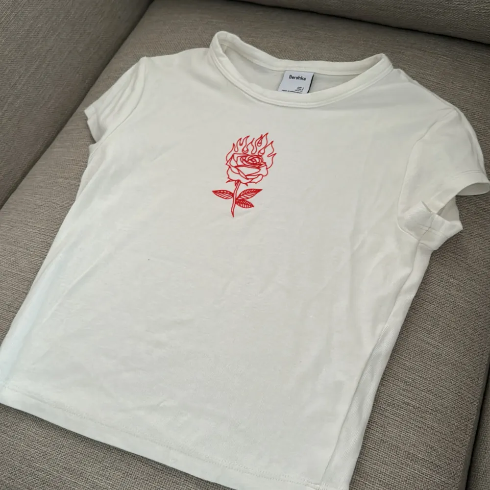 En fin t-shirt med en röd ros på🎀 köpte den från Bershka och har använt den 2-3 gånger 💗. T-shirts.
