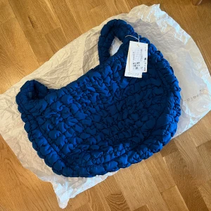 Cos quilted bag - The quilted bag is a cornerstone of the COS collection. Designed to be slung across the body or worn on your shoulder, this oversized version has enough room for everything you need for an overnight stay, and then some. It's crafted from 100% recycle