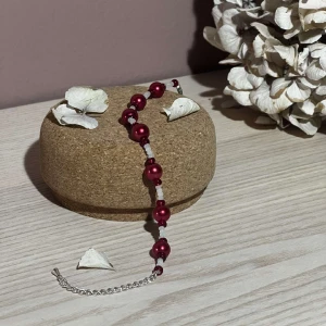 Armband- Zafira - Beskrivning: Detta armband är en ny design skapad av oss. Den består av röda pärlor med vita frostade pärlor mellan. Armbandet har en kedja i silver. Namn: Zafira Längd: Hela 22 cm, Pärlor 15 cm