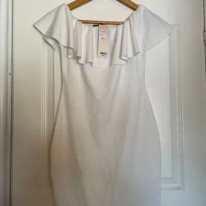 Vit off-shoulder klänning - Denna klänning passar perfekt till student, skolavslutning eller ett fint evenemang. Den är helt oanvänd och prislappen sitter kvar.