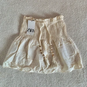 ZARA kjol i linneblandning med stenar - Otroligt vacker kjol från ZARA med stenar längs med snörena. Storlek XS men upplever den rymlig och passar definitivt även S. Ny med tags kvar. Spana gärna in mina andra annonser 🌹