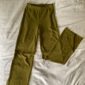 Byxor - Olivfärgad byxa med slits. Utsvängd. Mycket bra skick. Högmidjade.