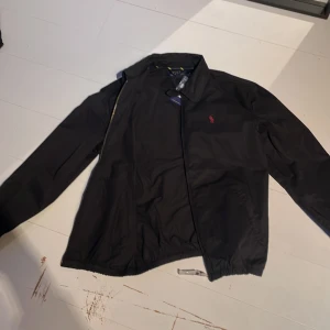 Polo Ralph lauren jacka  - Polo Ralph lauren harrington jacka funkar bra som övergångs jacka helt ny. Storlek L men lite kort i armarna. 