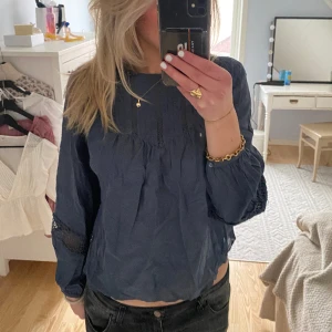 Blus  - Säljer denna grå-blå blus med snygga detaljer.