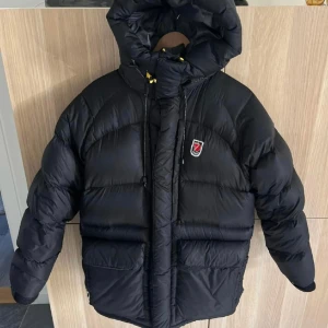 Fjällräven jacka  - Fjällräven Expedition Down Lite Jacket, svart i storlek S.  Mycket fint skick bortsett från att ena kardborren vid ärmslutet lossnat (se bild 3) Detta är dock inget som stör funktionen. Jackan är endast använd under en vinter. Inga revor eller hål. 