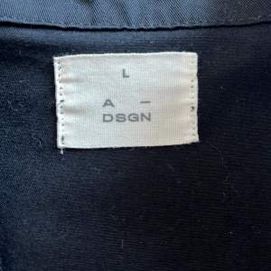 Säljer en svart kort skjorta från A-DSGN storlek L. Aldrig använd, 200kr. 