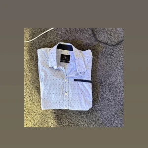 T shirt skjorta (herr) - Kortärmad skjorta i ljusblå färg. Strl  M (herr)