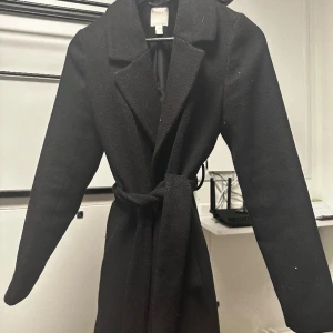 Svart kappa - Svart kappa med slits baktill från H&M som blivit för liten för mig tyvärr! Rollar såklart av den vid köp, kan tänka mig att gå ner i pris vid snabb affär 