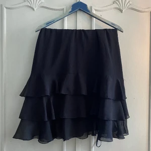 Svart klänning  - Fin svart klänning med volanger. Storlek 42 men skulle säga att den passar S-L beroende på hur en vill att den ska sitta. Så fin och i bra skick men säljer för att den tyvärr inte kommer till användning. Hör gärna av dig om du har några frågor! 