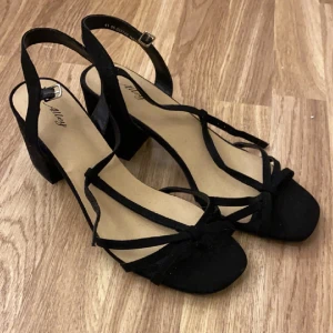 Svarta klackar - Ett par svarta, helt oanvända klackar med spänne vid vristen. Klacken är kort men väldigt stabil. Jättefin snörning vid tårna. Säljer då jag inte har någon användning av dem. Hör av dej vid frågor eller intresse💓💓