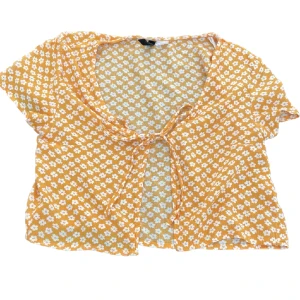 Blommig knyttopp - Orange knyttopp med lite genomskinligt tyg från H&M. På lappen står det XXS, men passar mig som vanligtsvis har storlek S. Säljer då den inte kommer till användning 😊Skriv gärna om du har frågor! 💕