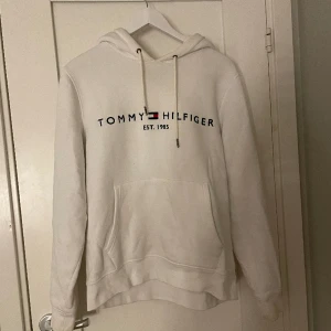 Tommy hiltfiger hoodie - Vit Tommy hiltfiger hoodie i fint skick Använd bara några få gånger men ser ut som ny Nypris: 1499kr Köparen står för frakten 