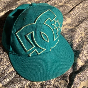 Turkos DC keps - En snygg DC som är använd men  i bra skick säljer den pga jag inte använder den och den passar inte mig storleken ser man på bild 3💓 