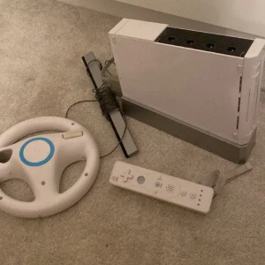 Wii - Ett wii som är i bra skick, sladden är lite tejpad men funkar som den ska, säljer för 500kr och man får med 2 dosor och 1 ratt