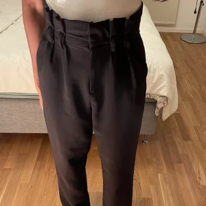 Högmidjade kostymbyxor  - säljer dessa högmidjade kostymbyxor med volanger från bikbok, de är rätt långa och sitter bra! De är i stl S men skulle även säga att de passar någon som är M. 