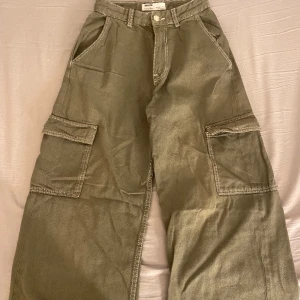 Gröna cargobyxor  - Säljer dessa cargobyxor i grön. Används mycket men är fortfarande i bra skick! Fickorna som sitter på bena är lite skrynkliga men det är bara att stryka. Köptes för 400 kr. OBS! Jag tvättar alltid plaggen innan jag skickar dom!