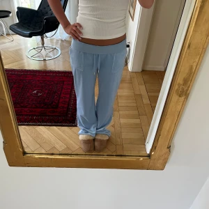 Juicy Couture byxor - Juicy Couture byxor i en fantastisk ljusblå färg. Storlek L men sitter snyggt oversized på mindre storlekar också. Har vikt med kanten på bild 1 och 3 för att få dem mer lågmidjade. Använda en gång då i princip helt nya. Nypris 1 195kr