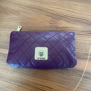 Moschino - Väskan är i ett okej skick. Nypris på väskan är ungefär 2800 men jag säljer den för 700 pga att det saknas ett kedjeband, vid frågor eller funderingar så är det bara att fråga!