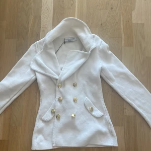 Mordern kofta  - Jätte fin vit kofta med guld detaljer! Om man önskar så kan man byta ut knapprna men de följs inte med andra knappar om du köper den! Inga fläckar aldrig använt stolek xs passar S tight i midjan passar till hösten o sommar kvällar  Skriv vid intresse