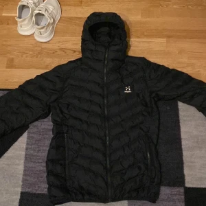Haglöfs dunjacka  - Stolek S fint skick en lagning som knappt syns. Haft på mig den i drygt 1 månad förra året. Väldigt skön jacka. Säljer den då jag växt ur den. Vid frågor eller fler bilder skriv privat. Mvh Melwin.