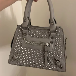 Glitter väska - Säljer denna snygga väskan som har små stenar på.Man får med ett band till väskan.  Skriv för fler bilder och frågor🥰 kan diskutera pris!!