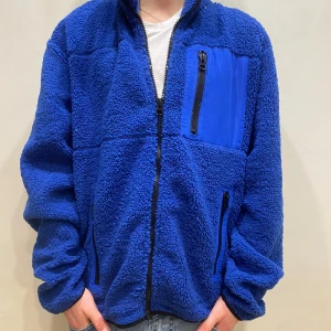 Fleece Jacka Lager 157  - Fleece Jacka lager 157  Modell: 184cm & väger 84kg  Skick: allmänt använd, textilfiber  Färg: blå Material: polyester 