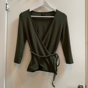 Omlottröja River Island (34) - Grön ribbad omlottröja från River Island i storlek 34. Väldigt fint skick 
