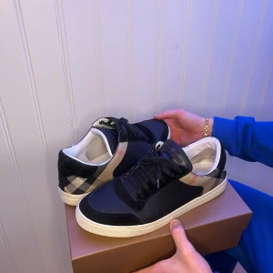 Burberry skor - Burberry skor      Modell: Burberry Reeth checked Leather sneakers              Storlek: 46  Bra skick  Vårt Pris: 2200  Nypris på burberrys hemsida: 6800 kr All og   Hör av dig vid frågor och funderingar mvh  