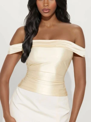 Champagnefärgad offshoulder korsett - Snygg offshoulder korsettopp i champagnefärgat satinliknande material. Toppen har en figurnära passform och markerad midja som ger en elegant siluett. Aldrig använt, kommer med lapp och i orginalförpackning. 