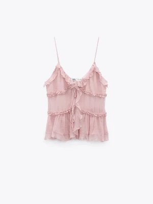 Rosa volangtop från Zara - Supersöt ljusrosa linnetopp från Zara med tunna axelband, volangdetaljer och knyt framtill. Toppen har en luftig och romantisk look som passar perfekt till sommaren. Materialet känns lätt och flowy.
