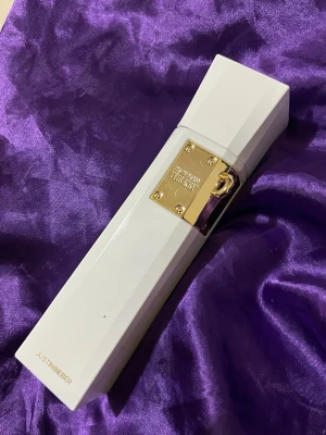 Justin Bieber The Key parfym - Säljer en parfym från Justin Bieber, modellen The Key. Flaskan är vit med gulddetaljer och har en modern, kantig design. Märket och parfymnamnet står på en guldfärgad metallplatta framtill. Perfekt för dig som gillar snygga och trendiga dofter.