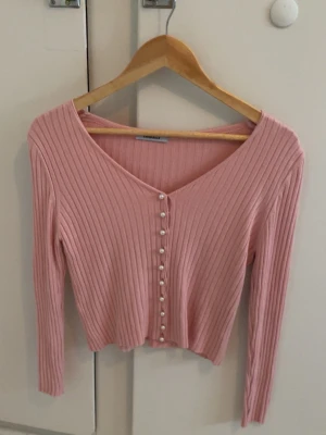 Rosa ribbad kofta med pärlknappar - Säljer för 100kr