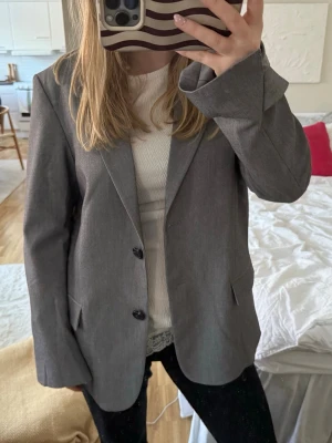 Snygg ljusgrå kavaj  - Säljer en supersnygg grå kavaj från Monki, den är i storlek xxs och endast använd fåtal gånger. Stor i storleken då jag i vanliga fall är en xs/s & är 163 cm, för referens 😇 superfint skick! Säljs då jag behövde rensa bland kavajerna.